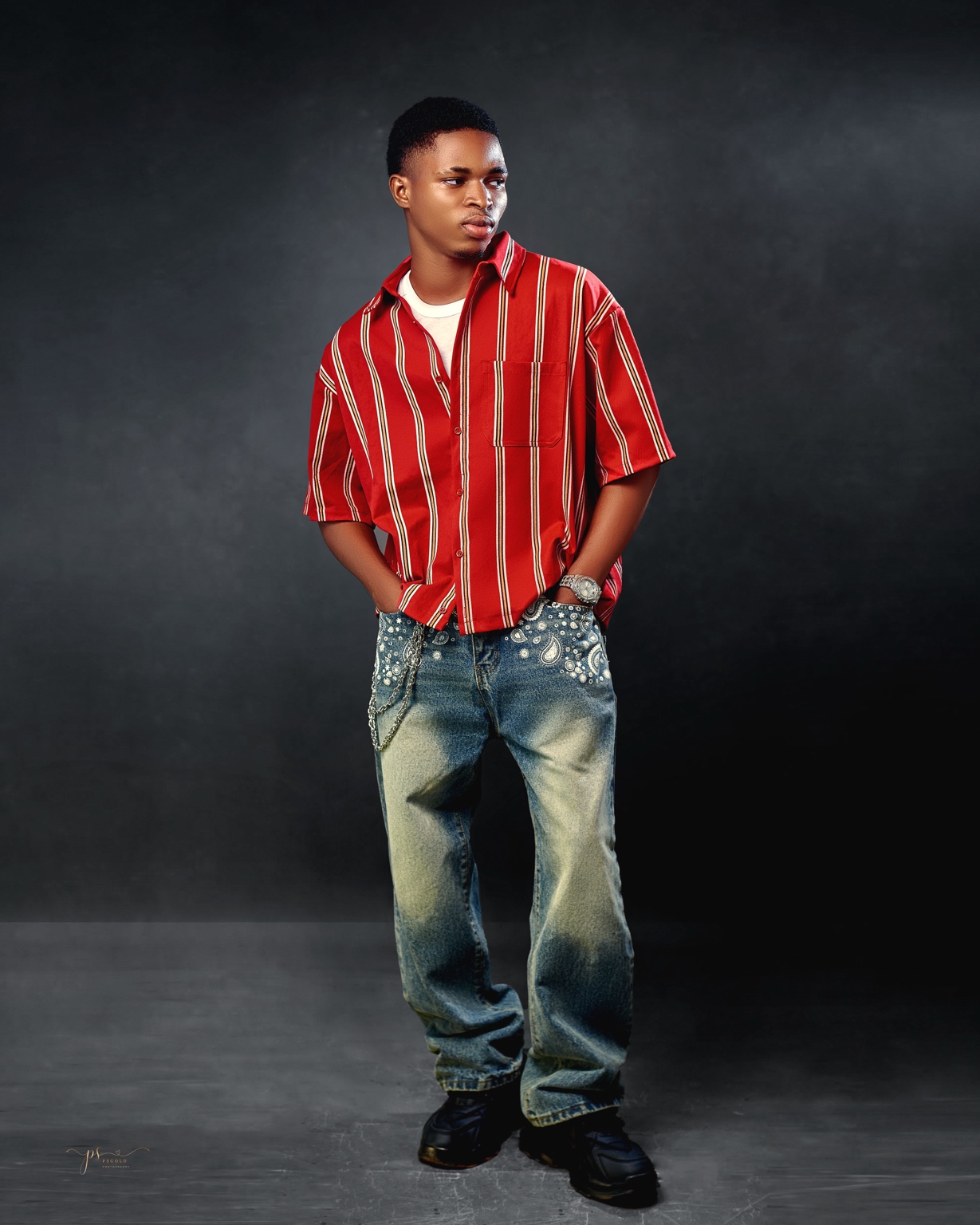 Emmanuel Adeyemi in a red striped shirt during a studio shoot